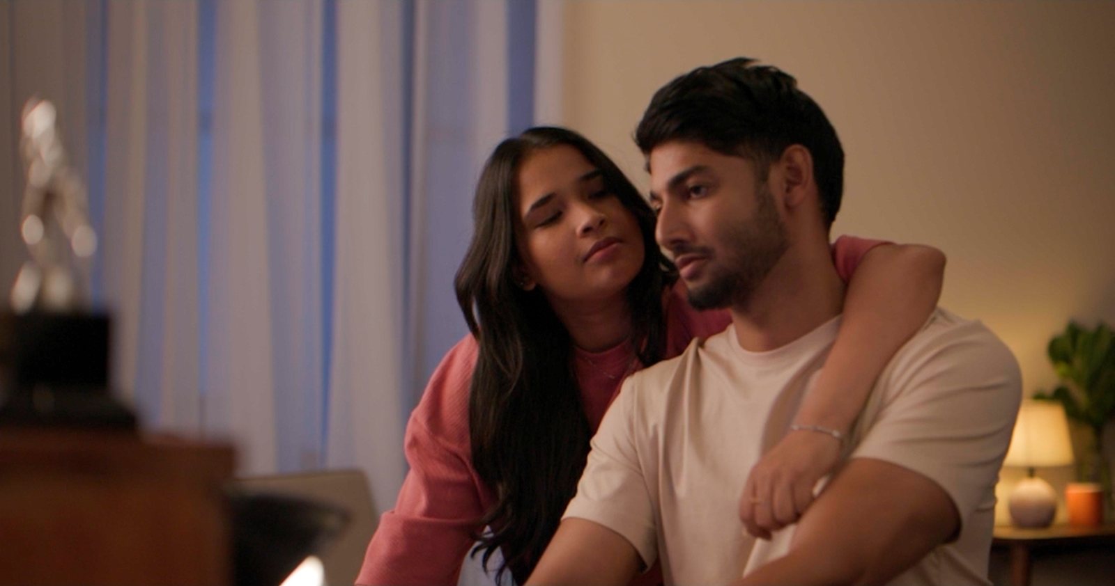 A couple in a warm-lit interior at night